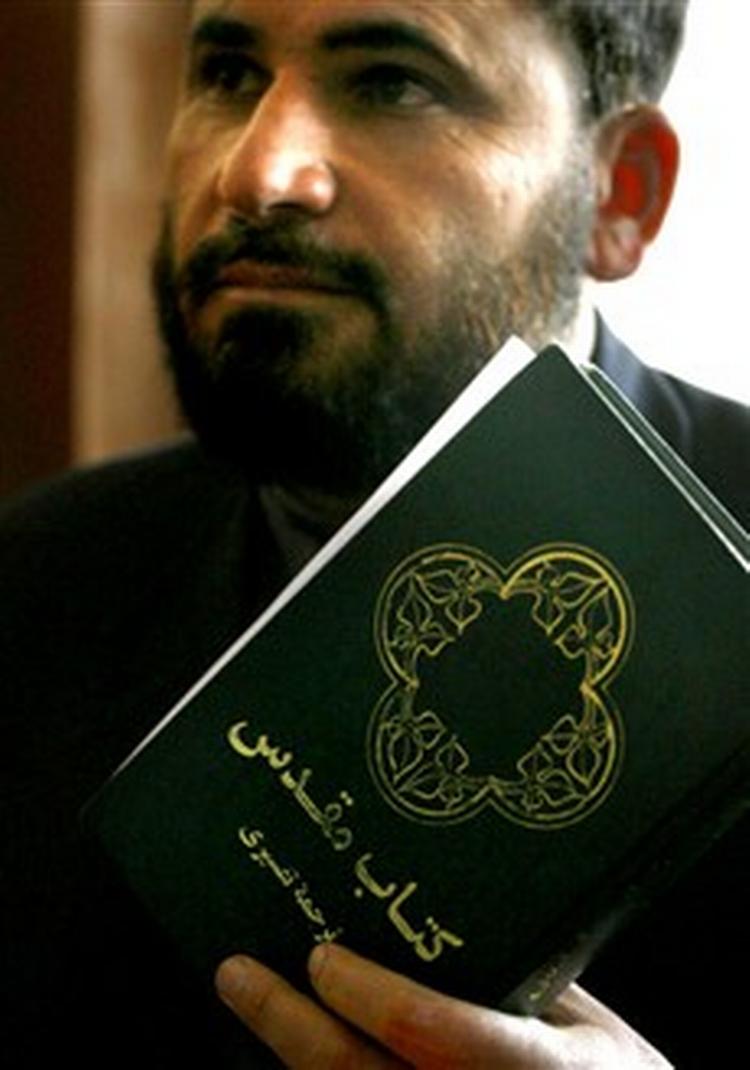 Højestertsdommer Ansarullah Mawlavezda med den bibel, som den 41-årige Abdul Rahman havde på sig, da han blev forhørt af politiet.   Foto: AP 