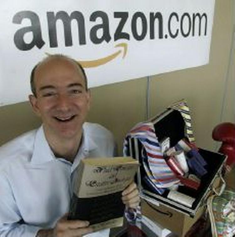 En af grundlæggerne bag Amazon, Jeff Bezos, fremviser et eksemplar af den første bog, der blev solgt online. Firmaet afviser beskyldningerne om Amazon som abortmodstander. - Arkivfoto: AP 