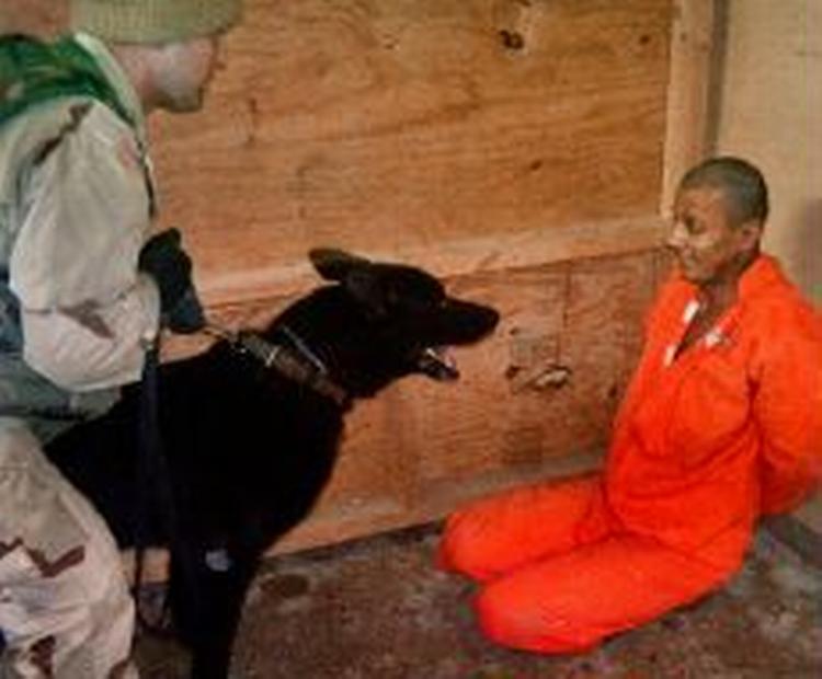 Sergent Michael Smith blev kendt i offentligheden efter billeder som dette, hvor han lader sin hund true en fange i Abu Ghraib-fængslet. - Arkivfoto: AP 