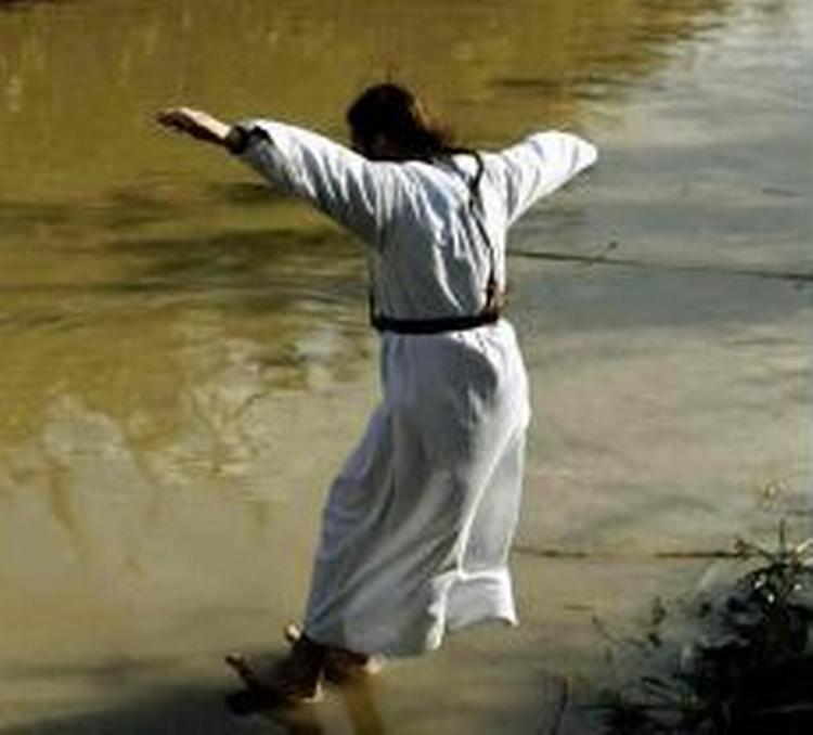 En amerikansk forsker har fundet en videnskabelig forklaring på, hvordan Jesus kunne gå på vandet. Manden på billedet forsøger dog ikke at gå på vandet, men er en pilgrim, der hopper i Jordan Floden, hvor man mener, Jesus blev døbt. - Arkivfoto: AP 