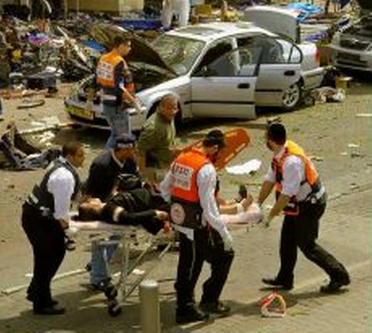 En såret kvinde bæres bort fra området af redningsarbejdere. - Foto: AP 