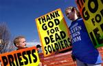 Tiårige Gabriel Phelps-Roper og hans tre år ældre søster Grace fra den lille Westboro Baptistkirke demonstrerer deres jubel over soldaters død ved begravelsen af marinesoldaten Matthew A. Snyder i sidste måned. - Foto: AP 
