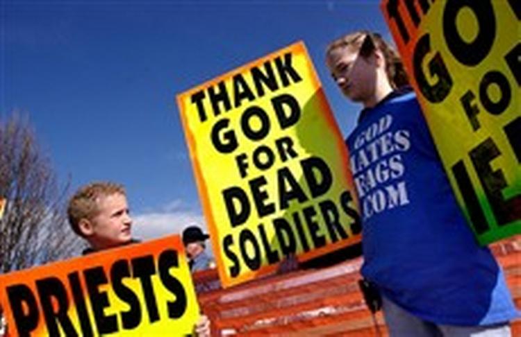 Tiårige Gabriel Phelps-Roper og hans tre år ældre søster Grace fra den lille Westboro Baptistkirke demonstrerer deres jubel over soldaters død ved begravelsen af marinesoldaten Matthew A. Snyder i sidste måned. - Foto: AP 