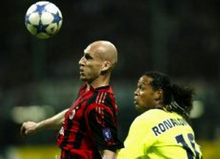 Barcelonas stjernespiller Ronaldinho kæmper med AC Milans Jaap Stam fra Holland om bolden under semifinalen i Milano. - Foto: AP 