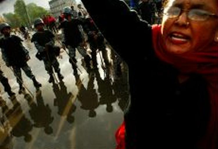 En demonstrant råber slogans foran en kæde af politifolk i Nepals hovedstad, Kathmandu. - Foto: AP 