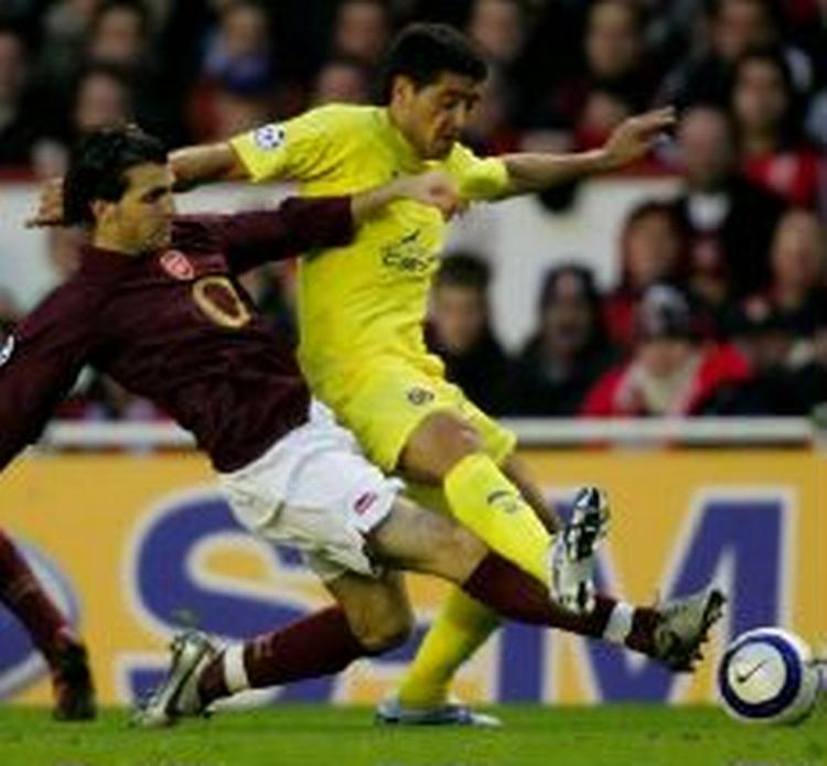 Villarreals Juan Ramon Riquelme fra Argentina kæmper om bolden med Arsenals Francesc Fabregas i semifinalen i Champions League. - Foto: AP 