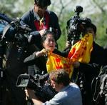 Den protesterende kvinde viftede med et flag med de røde og gule farver, symboliserende Falun Gong.- Foto: AP 