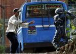 En betjent truer en demonstrant i Kathmandu, hvor tusindvis af nepalesere igen i dag har været på gaden. - Foto: AP 