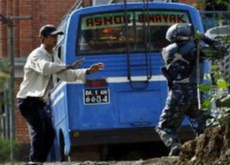 En betjent truer en demonstrant i Kathmandu, hvor tusindvis af nepalesere igen i dag har været på gaden. - Foto: AP 