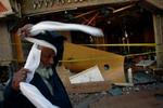 En egyptisk mand i færd at tage tørklæde på foran en bomberamt restaurant i Dahab. - Foto: AP 