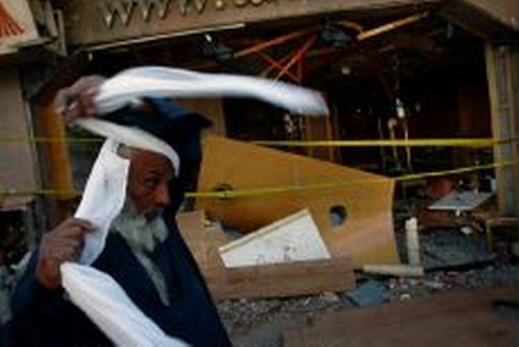 En egyptisk mand i færd at tage tørklæde på foran en bomberamt restaurant i Dahab. - Foto: AP 