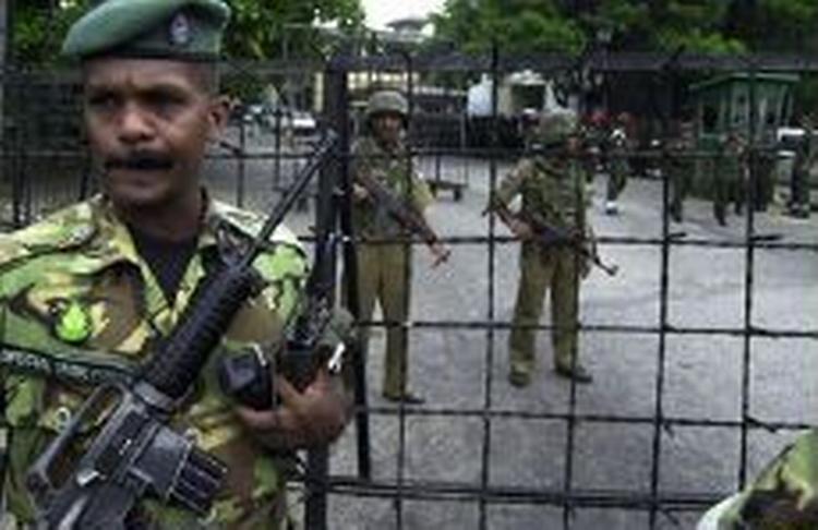 Soldater står vagt ved indgangen til Sri Lankas militære hovedkvarter, hvor en selvmordsbomber i dag dræbte otte og sårede hærchefen. - Foto: AP 