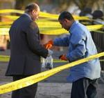En repræsentant fra de egyptiske myndigheder indsamler rester fra bomberne i Dahab. - Foto: AP 