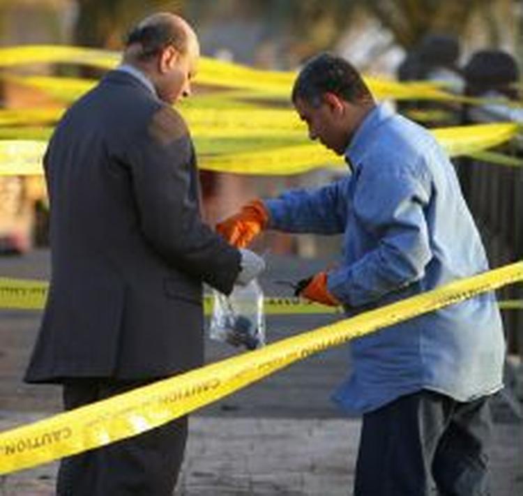 En repræsentant fra de egyptiske myndigheder indsamler rester fra bomberne i Dahab. - Foto: AP 