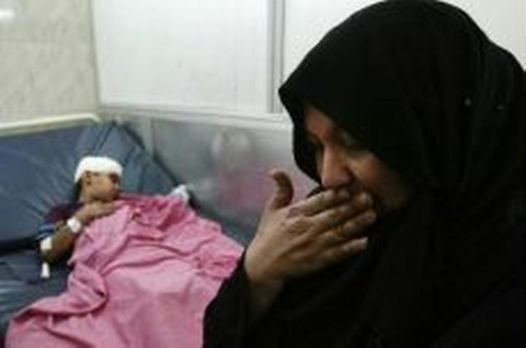 En mor sørger over sin sårede søn efter et bombeangreb i det vestlige Bagdad i dag. - Foto: AP 