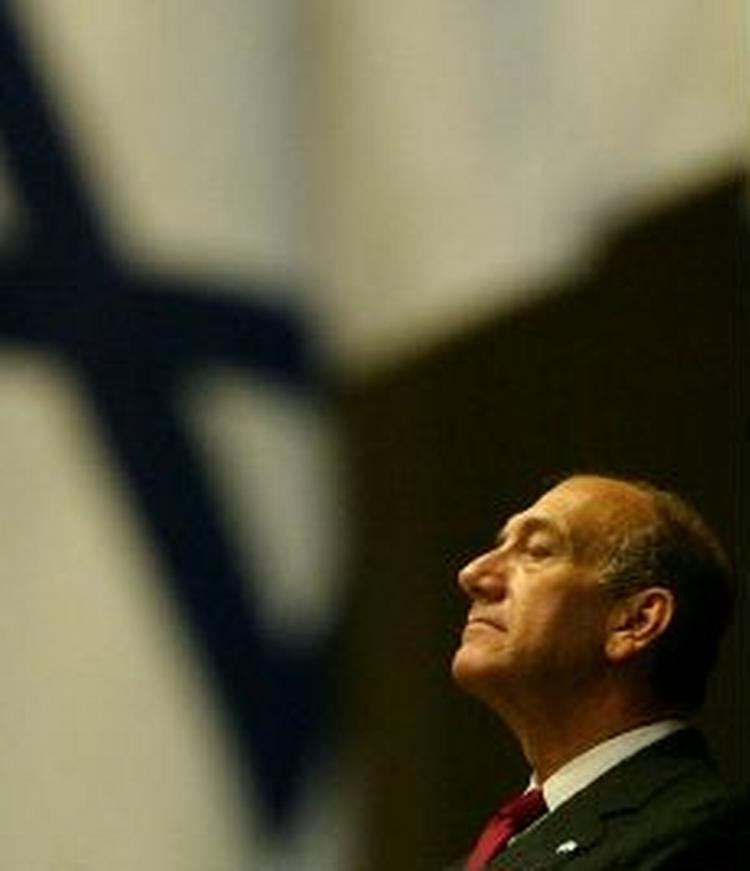 Ehud Olmert med det israelsk flag i baggrunden. Udviklingen i Iran vækker minder om nazi-tiden, mener han. - Arkivfoto: AP 