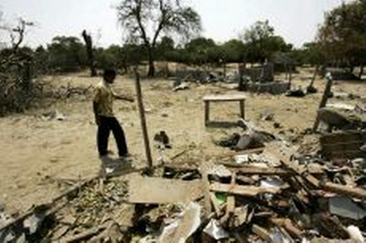 En tamilsk oprører ser på ødelæggelser efter regeringshærens flyangreb mod baser i Sampur i det nord-østlige Sri Lanka. Nu er oprørsgrupper også begyndt at slås indbyrdes. - Foto: AP 