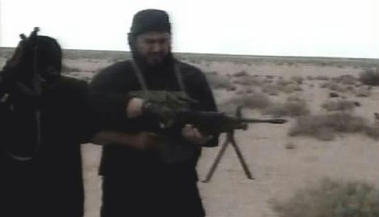 Abu Musab al-Zarqawi får hjælp til at betjene sit våben. - Foto: AP 