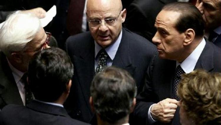 Berlusconi (th.) diskuterer med andre parlamentarikere før afstemningen. - Foto: AP 