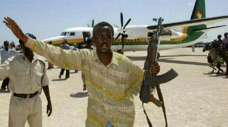 En bevæbnet mand holder folk væk fra landingsbanen, da talsmanden for det somaliske parlament lander i Mogadishu. Stemningen er højspændt i det afrikanske land. - Foto: AP 