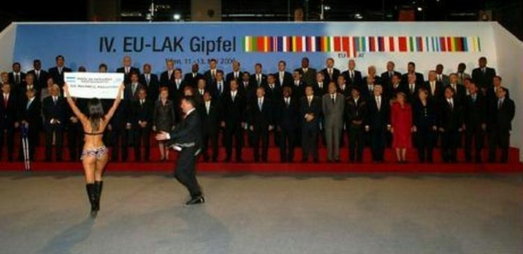 En argentinsk Greenpeace-aktivist i bikini protesterer mod forurening foran de 58 topledere fra EU og Latinamerika, mens en vagt iler til for at eskortere hende ud. Derudover var der mest fokus på Evo Morales. - Foto: AP 