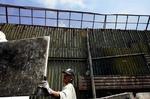 En arbejder er i gang med at reparere det metalhegn, som de amerikanske myndigheder har sat op mellem Mexico og USA for at holde indvandrere ude. - Foto: AP 