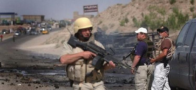 En sikkerhedsvagt standser trafikken efter et bilbombeangreb i Herat i landets vestlige del. - Foto: AP 