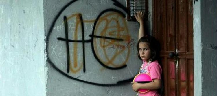 En pige ringepå døren ved siden af en graffiti-opfordring til at stemme NEJ. - Foto: AP 