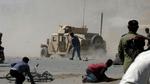Vrede afghanerne kaster sten efter et amerikansk militærkøretøj under optøjer i Kabul i dag. - Foto: AP 