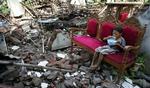 En lille dreng får en skål ris i ruinerne i en landsby i Bantul-distriktet. - Foto: AP 