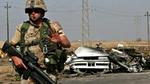 En dansk soldat bevogter vejen, hvor en bil er blevet sprængt i stykker i Basra 20. april. De danske tropper får en central placering i koalitionen i Irak, mens andre lande reducerer styrkerne. - Arkivfoto: AP 
