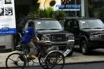 Et vietnamesisk cykelbud kører forbi den amerikanske bilkoncern Fords lokaler i Ho Chi Minh by. I dag er en historisk samhandelsaftale underskrevet mellem de to lande. - Foto: AP 