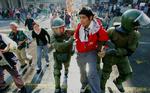 Politi anholder en studerende efter omfattende demonstrationer i Santiago, Chile. - Foto: AP 