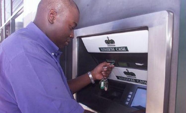 En zimbabwer forsøger at hæve penge i en automat i Harare. På grund af akut mangel på penge udsteder regeringen nu en 100.000 dollar seddel. - Arkivfoto: AP 