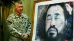 En amerikansk soldat præsenterer umiddelbart efter luftangrebet i Baluqa et billede af den døde terrorleder - for hurtigst muligt at overbvise pressen om, at det virkelig var Zarqawi. - Foto: AP 