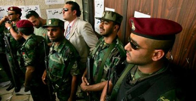 Palæstinensiske sikkerhedsstyrker bevogter indgangen til parlamentet mod Fatah-tilhængere, der gerne vil ind til debatten. - Foto: AP 