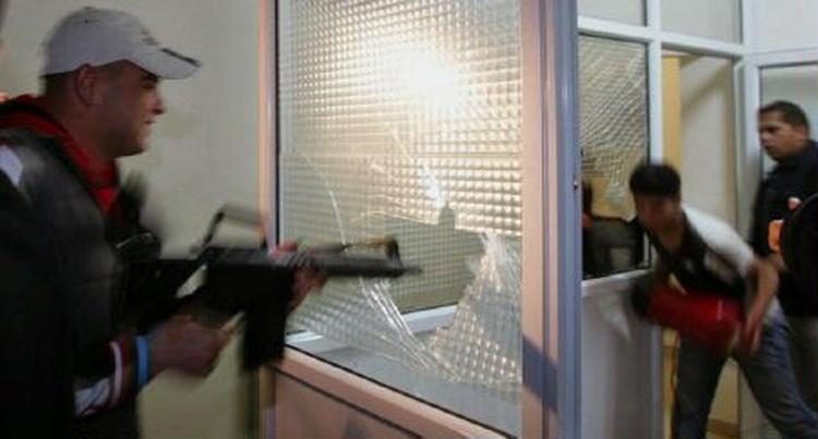 En militant Fatah-tilhænger ødelægger et vindue i parlamentet i Ramallah. - Foto: AP 