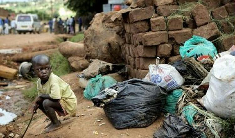 En dreng leger i affaldet i et slumkvarter i Ugandas hovedstad Kampala. - Arkivfoto: Thomas Borberg 