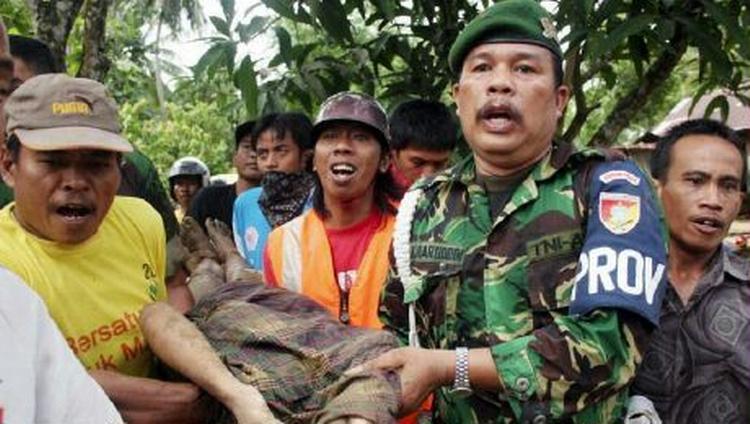 Hæren og lokale redningsfolk bærer et offer for mudderskred i Indonesien væk. - Foto: AP 