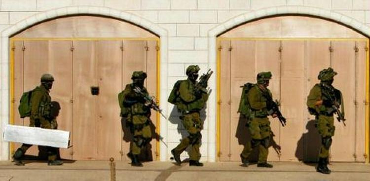 Israelske soldater omringer en bygning på Vestbredden, hvor en bosætter er meldt savnet efter gidseltagningen af den israelske soldat i Gaza. - Foto: AP 