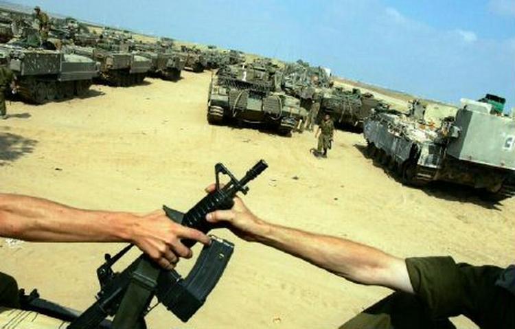 Israelske soldater venter på at komme i aktion i dag ved Gazastriben. Missiler har ødelagt et elværk i Gaza. - Foto: AP 