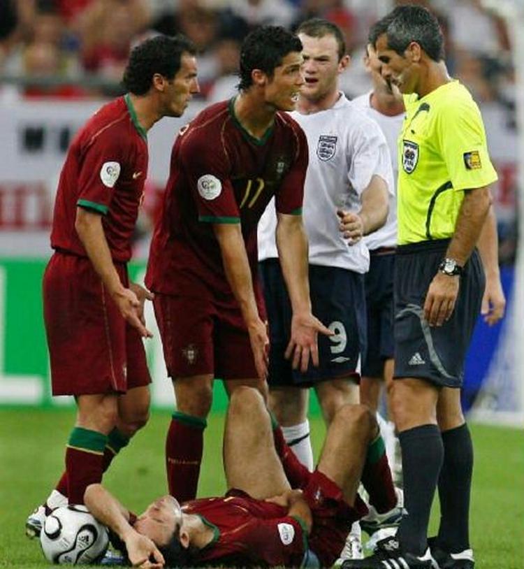 Den argentinske dommer giver Wayne Rooney et rødt kort - her brokker Christiano Ronaldo sig over frisparket, der ledte op til udvisningen. - Foto: AP 