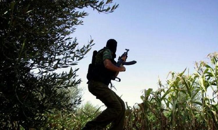 Et maskeret medlem af den militante gruppe Al-Aqsa Brigaderne dukker sig i Gaza, da en israelsk kamphelikopter flyver over området. - Foto: AP 