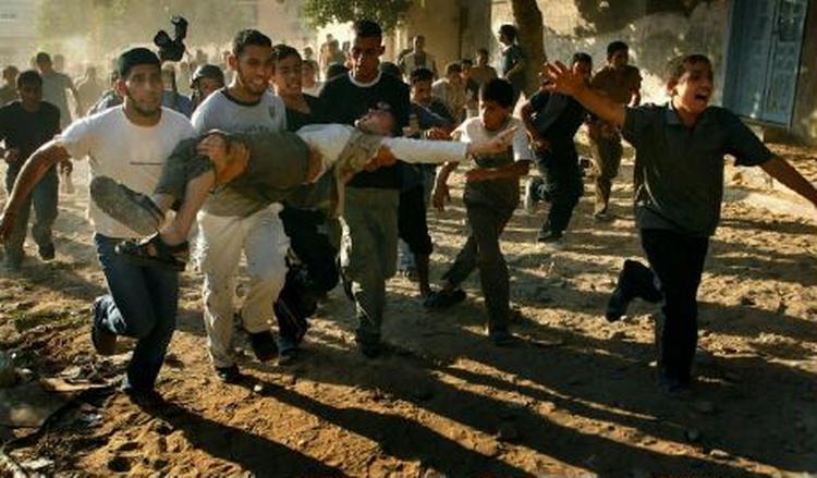 Palæstinensere bærer sårede væk fra et område, der i dag blev ramt af israelske granater. Hamas' indenrigsminister opfordrer nu sikkerhedsstyrkerne til at angribe de israelske soldater i Gaza. - Foto: AP 