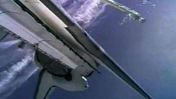 NASA bliver nødt til at lade rumfærgen Discovery blive i rummet et døgn ekstra, fordi man frygter at varmeskjoldet kan få færgen til at brænde op, når den rammer jordens atmosfære - Foto: AP/NASA 