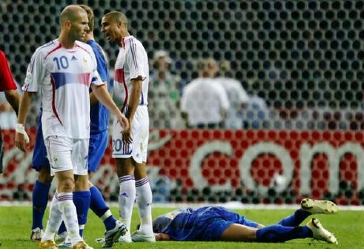 Franske Zinedine Zidane har strakt Marco Materazzi til jorden med en skalle. Det franske hold angriber nu den italienske forsvarer. - Foto: AP 
