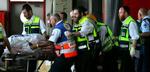 Sårede og omkomne bæres ud fra togstationen i Haifa. - Foto: AP 