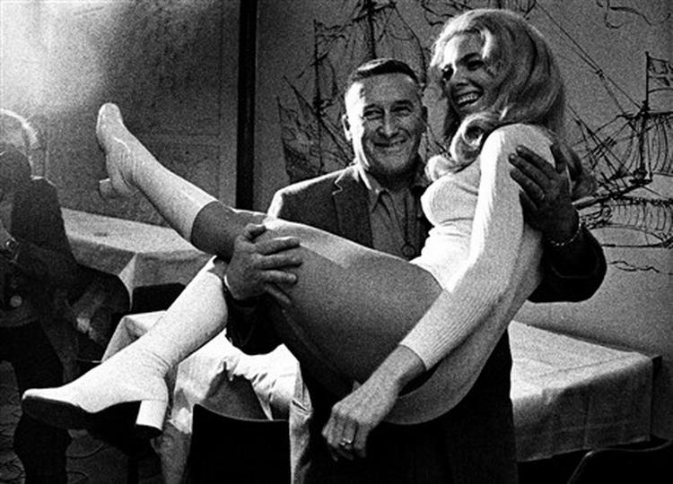 Nedenfor foto fra den forrygende filmatisering af Mickey Spillanes hovedværk,  Kys mig til døde  med Ralph Meeker som den psykopatiske detektiv, Mike Hammer. Ovenfor ses Mickey Spillane med konen Sherri i 1973.   Foto fra filmen og Polfoto 