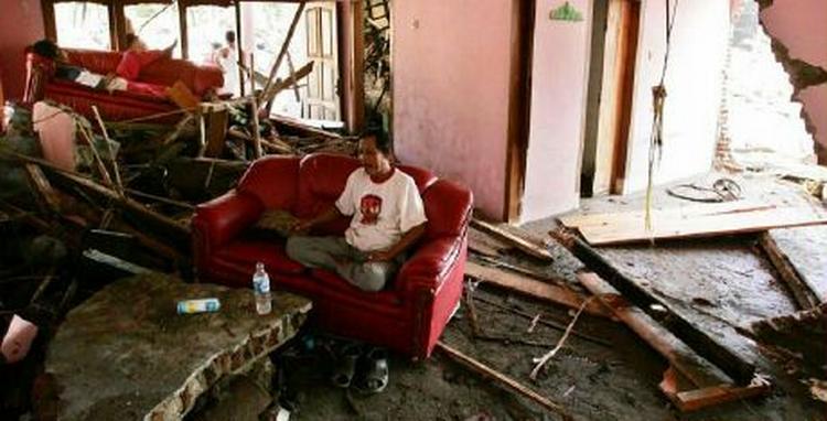 En indonesisk mand sidder i sin stue, der blev ramt af tsunamien. - Foto: AP 