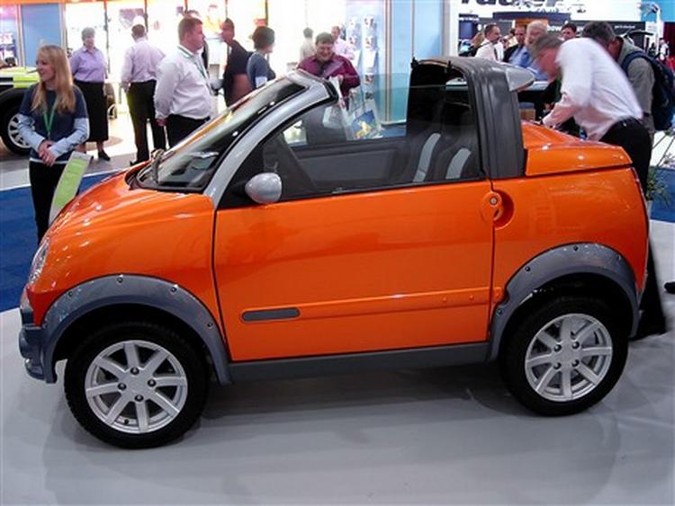 Lige nu er det stegende hedt i London, og så er det måske for meget af det gode at køre i åben bil. Alligevel vil franske Mega gerne sælge denne lille fikse cabriolet med elmotor til Londons bilister. Foto: Allan Graubæk 